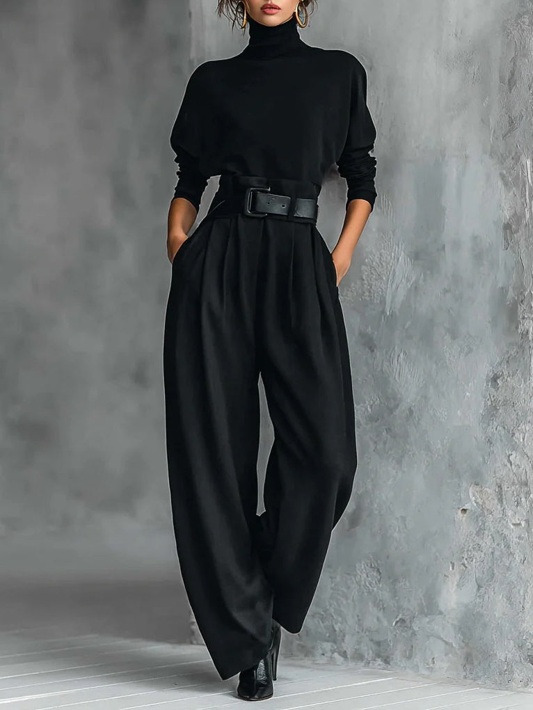 Conjunto de dos piezas compuesto por camiseta de cuello alto y manga larga totalmente negra y pantalones rectos (incluye cinturón).