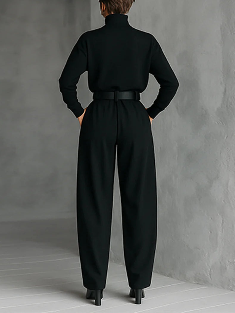 Conjunto de dos piezas compuesto por camiseta de cuello alto y manga larga totalmente negra y pantalones rectos (incluye cinturón).