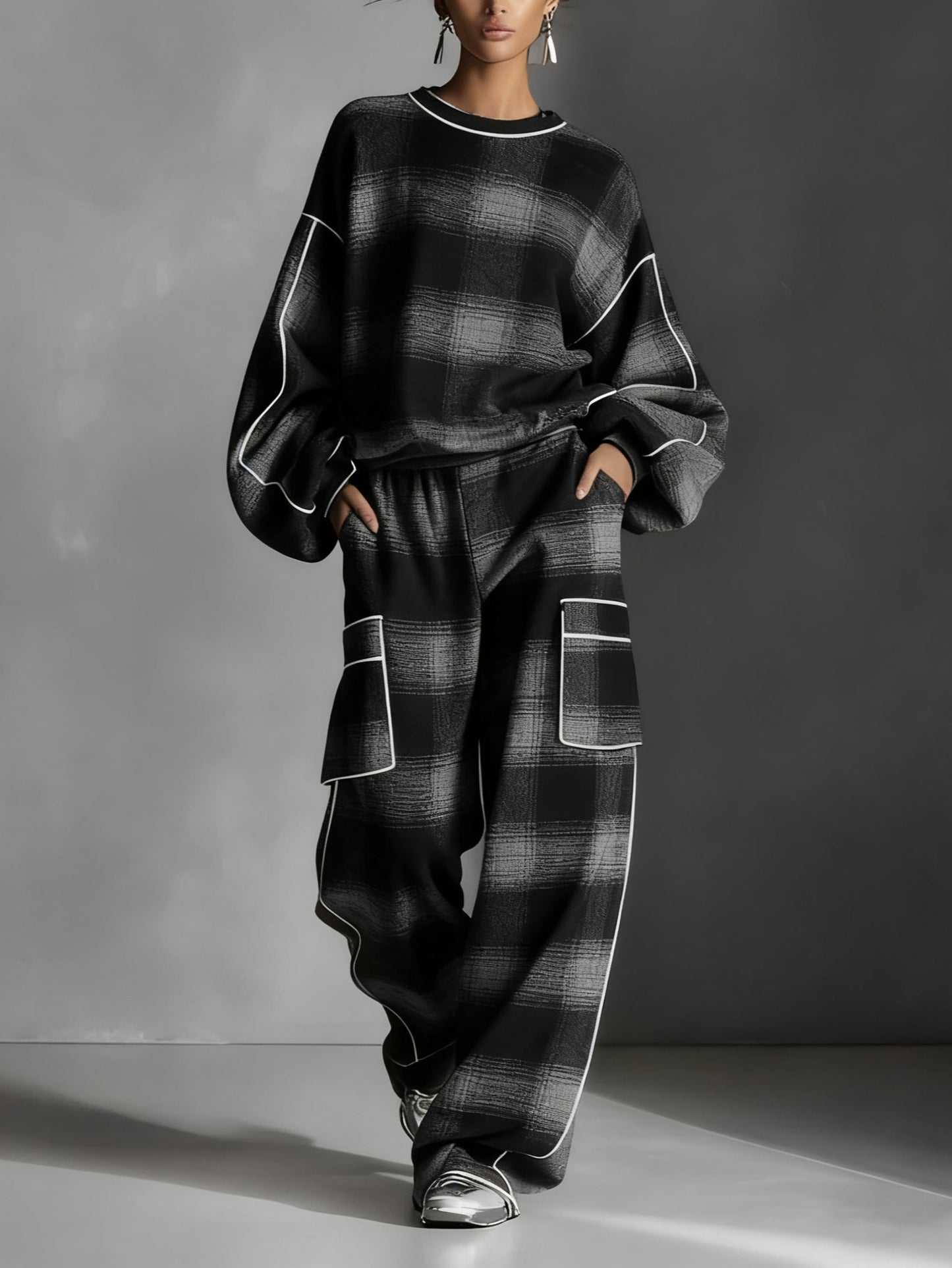 Conjunto de dos piezas compuesto por sudadera con bloques de color a cuadros negros y grises y pantalones informales.