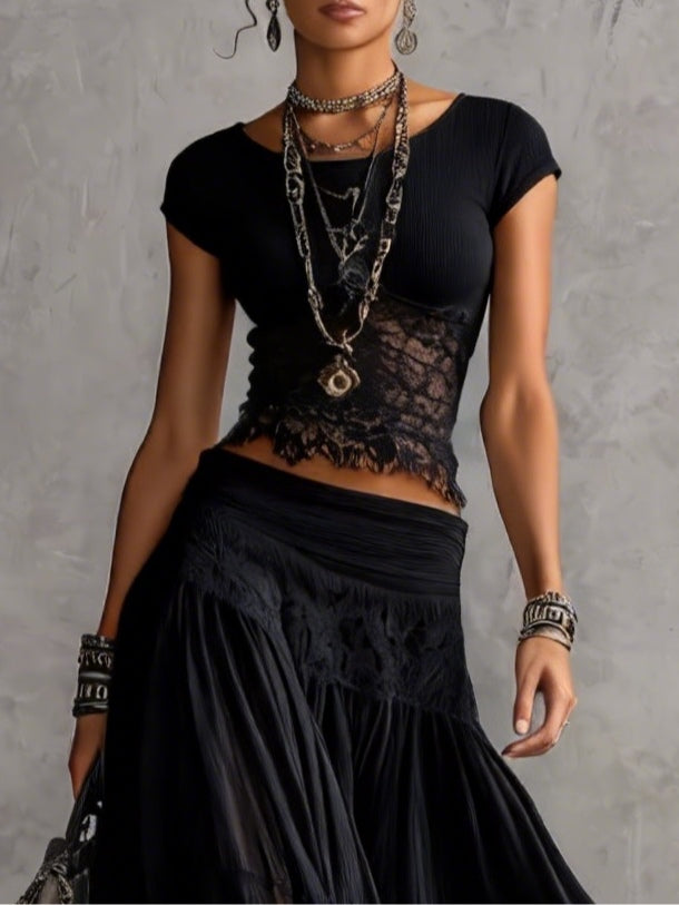 Conjunto negro compuesto por un top de encaje transparente y una falda larga plisada